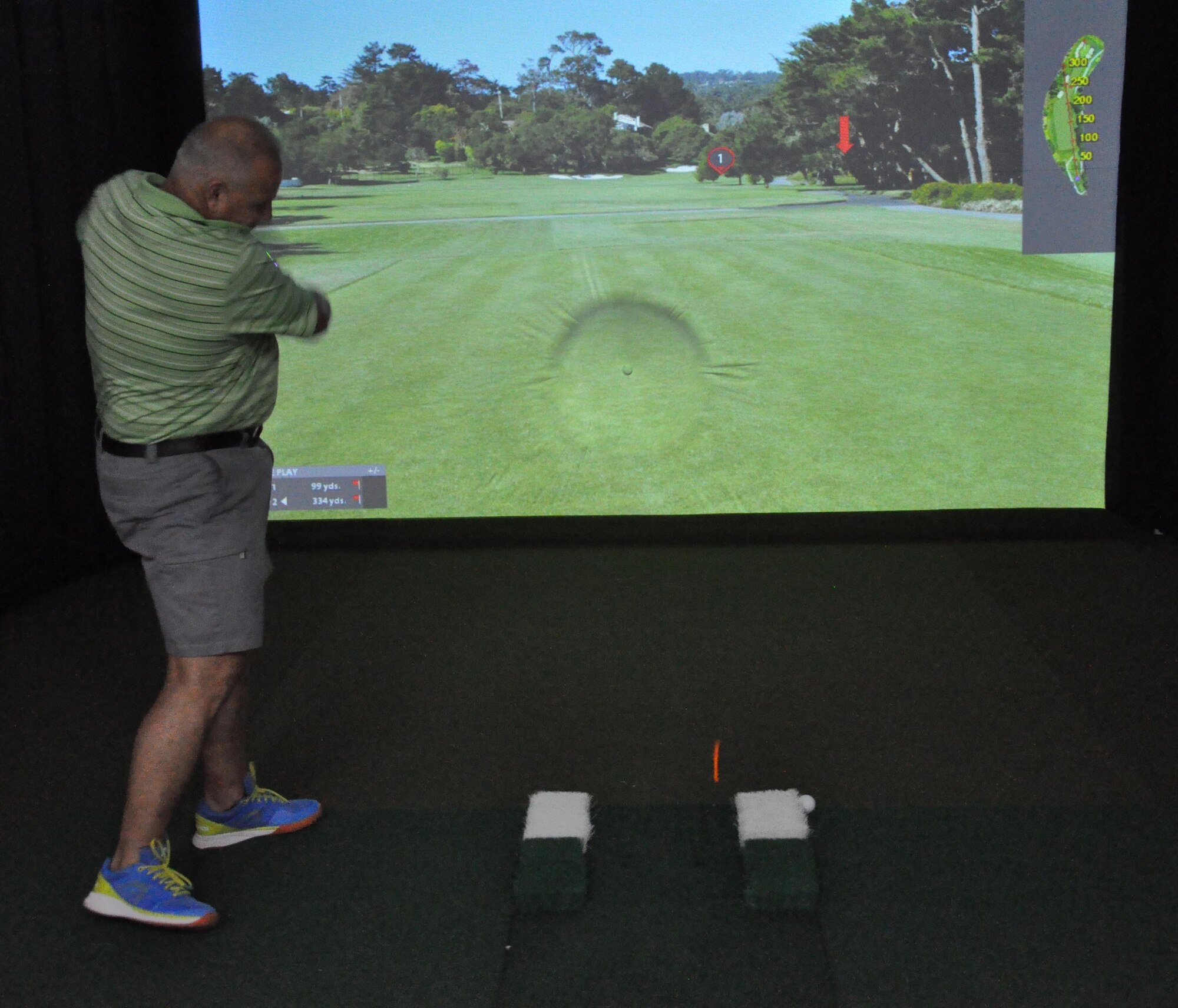 Retired Chief Master Sgt. Joey McCoy hits a golf ball into the screen of the high definition golf simulator inside the Blatchford Preston Complex Community Activity Center at Al Udeid Air Base, Qatar, Jan. 16. McCoy said he enjoys playing golf and the simulator provides golfers with a realistic golfing experience. The simulator offers practice and competition modes, as well as one-on-one instruction from a virtual golf coach. (U.S. Air Force photo by Tech. Sgt. James Hodgman)