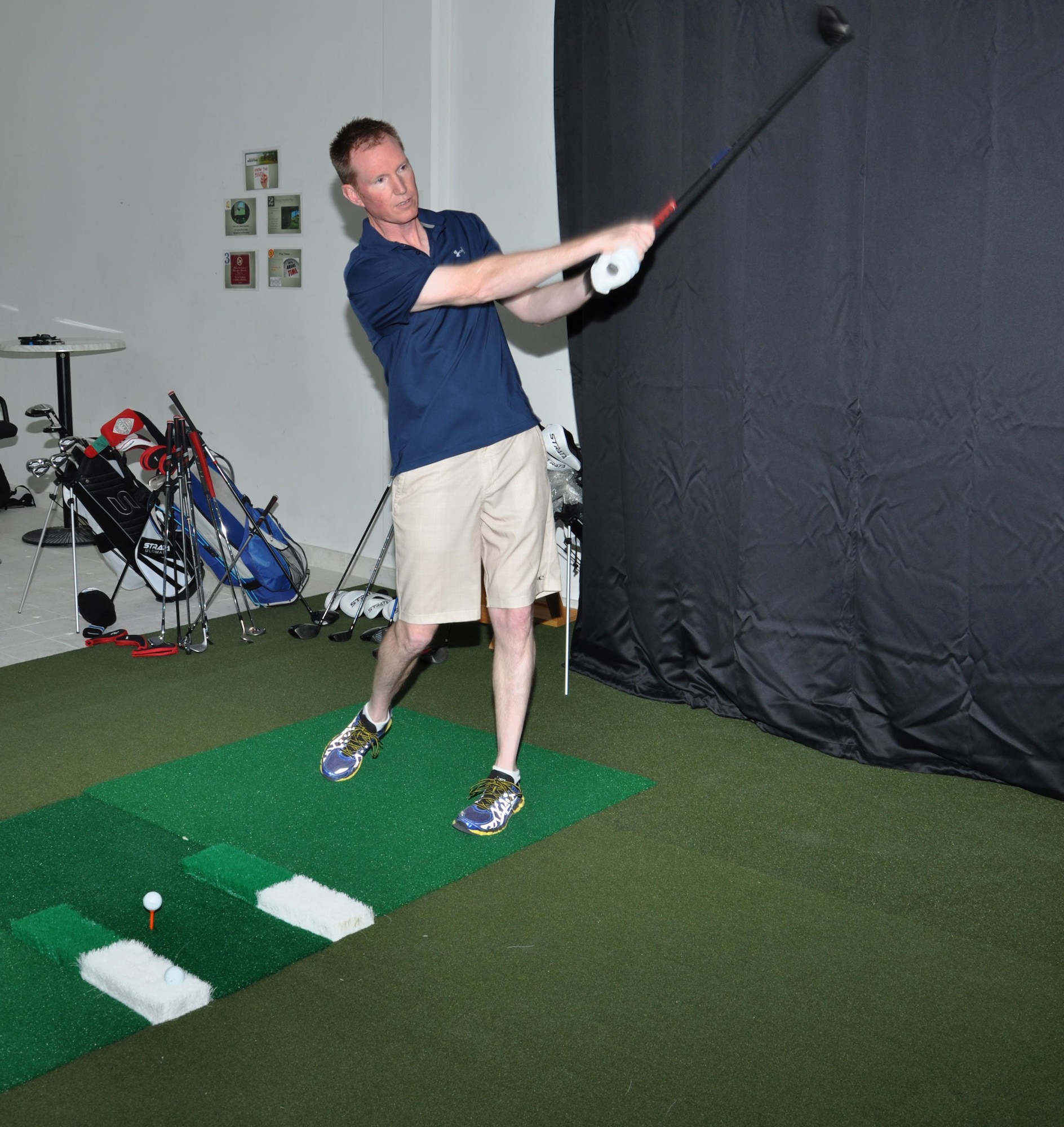 Col. Stuart Newberry, 379th Air Expeditionary Wing vice commander, hits a golf ball into the screen of the high definition golf simulator inside the Blatchford Preston Complex Community Activity Center at Al Udeid Air Base, Qatar, Jan. 16. Newberry, an avid golfer, said the simulator’s graphics were amazing. The simulator offers practice and competition modes, as well as one-on-one instruction from a virtual golf coach. (U.S. Air Force photo by Tech. Sgt. James Hodgman)