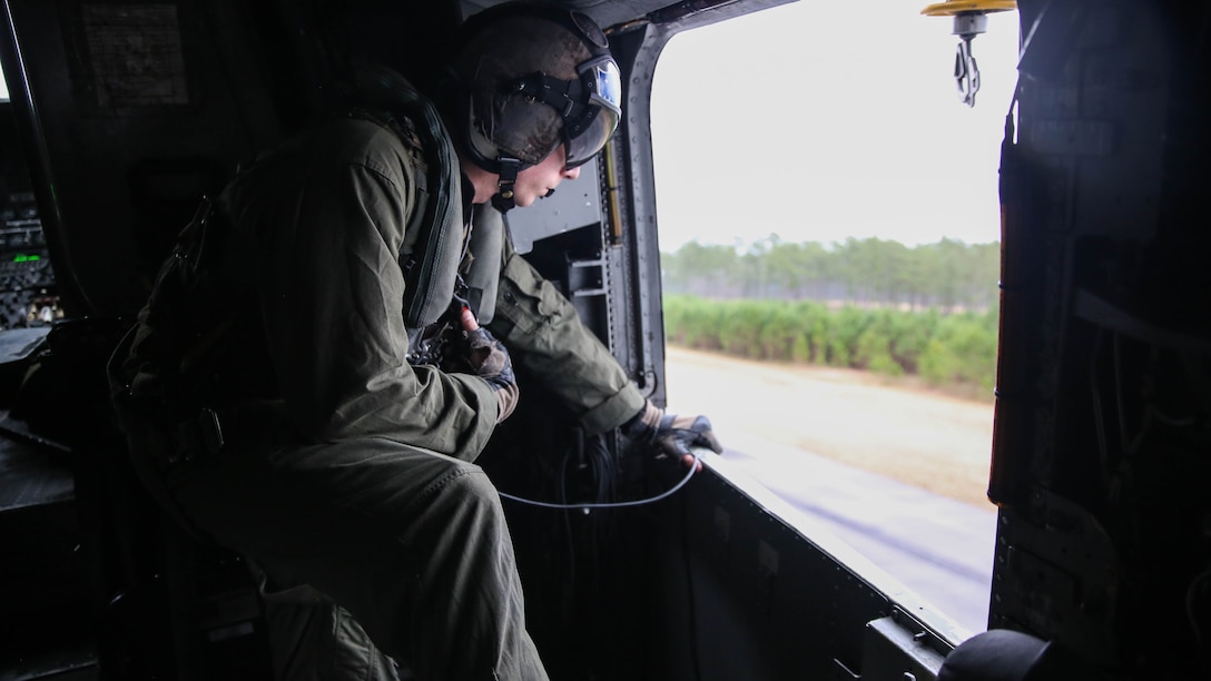 Cpl. Cody J. Vitols, a crew chief of a CH-53E Super Stallion, with Marine Heavy Helicopter Training Squadron 302, monitors and relays information to pilots during a flight at Marine Corps Air Station New River, N.C., Jan. 7, 2016. Marine student pilots practiced maneuvering and landing for the first time in the aircraft. 