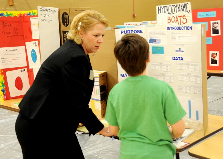 Karen Moore, a lead project manager with the Huntsville Center's Energy Division, listens as Fifth-grader Trevor DeMont explains his "Hydrodynamic Boat" presentation during the Challenger Elementary School Science Fair Jan. 20. DeMont placed third in the physical category of the school’s science fair and will move forward to the Regional Science Fair competition.
