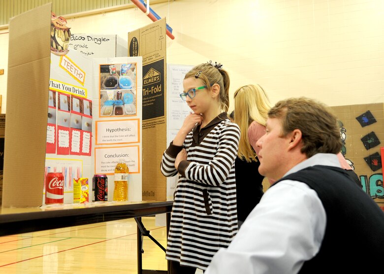 Wade Doss, Huntsville Center’s Civil Structures Division chief, gets on Hannah Long’s level as she goes over her third grade science fair project that explains how different substances affect teeth during the Challenger Elementary School Science Fair Jan. 20.