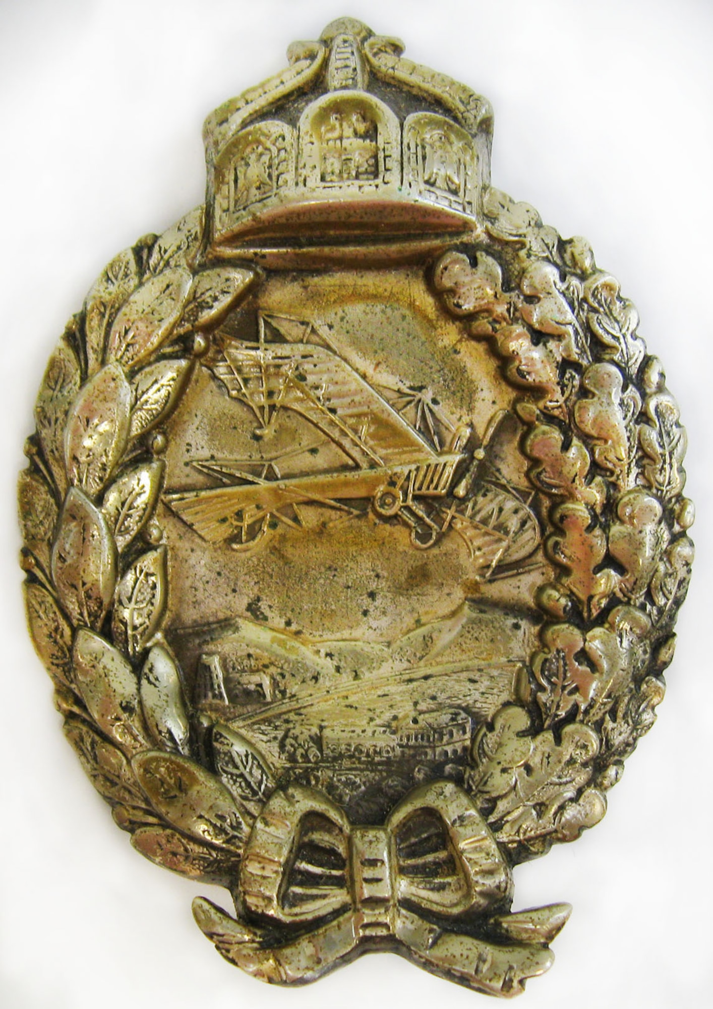 At the outbreak of World War I, LeRoy J. Prinz went to France to train as a pilot. Initially, he served in the French Aviation Corps, then with the 94th Aero Squadron and the 27th Aero Squadron. This aviator pin has a front design of a wreath with bow at bottom and a triptych crown at top. Centered within the wreath opening is a scene of an aircraft flying over mountains, fields and buildings in Europe. The back is engraved: HANS EHL,  SHOT DOWN,  JULY 1 1917,  BY LE ROY PRINZ (U.S. Air Force photo)
