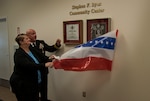 In front of family members, friends and co-workers, the Stephen F. Byus Community Center was dedicated Jan. 21 during a ceremony on the installation. Suzanna Byus, Stephen's mother, and Navy Rear Adm. John King, DLA Land and Maritime commander, unveil the plaque that will be permanently displayed inside the center.