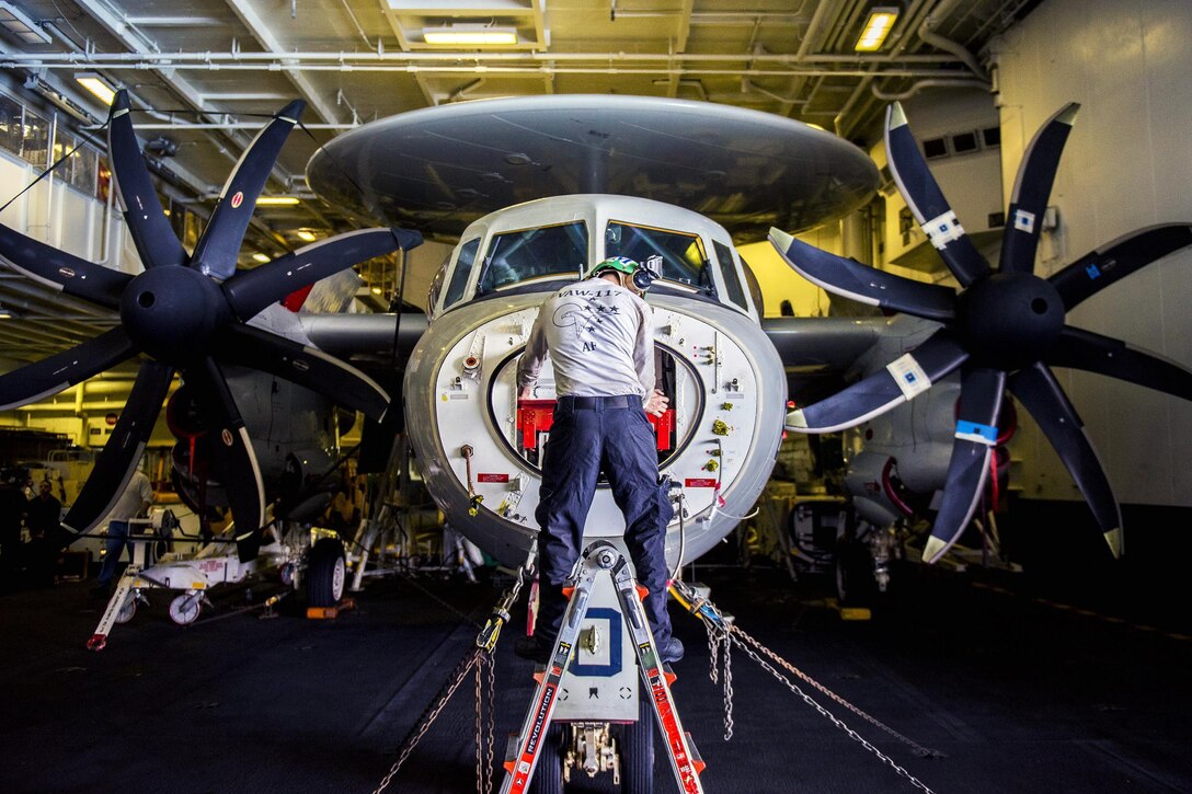 U.S. Navy Petty Officer 2nd Class D. Lopez performs maintenance on an E-2C Hawkeye in the hangar bay of the aircraft carrier USS Harry S. Truman in the Arabian Gulf, Jan. 21, 2016. Lopez is an aviation structural mechanic assigned to Carrier Airborne Early Warning Squadron 117. U.S. Navy photo by Petty Officer 3rd Class Justin R. Pacheco