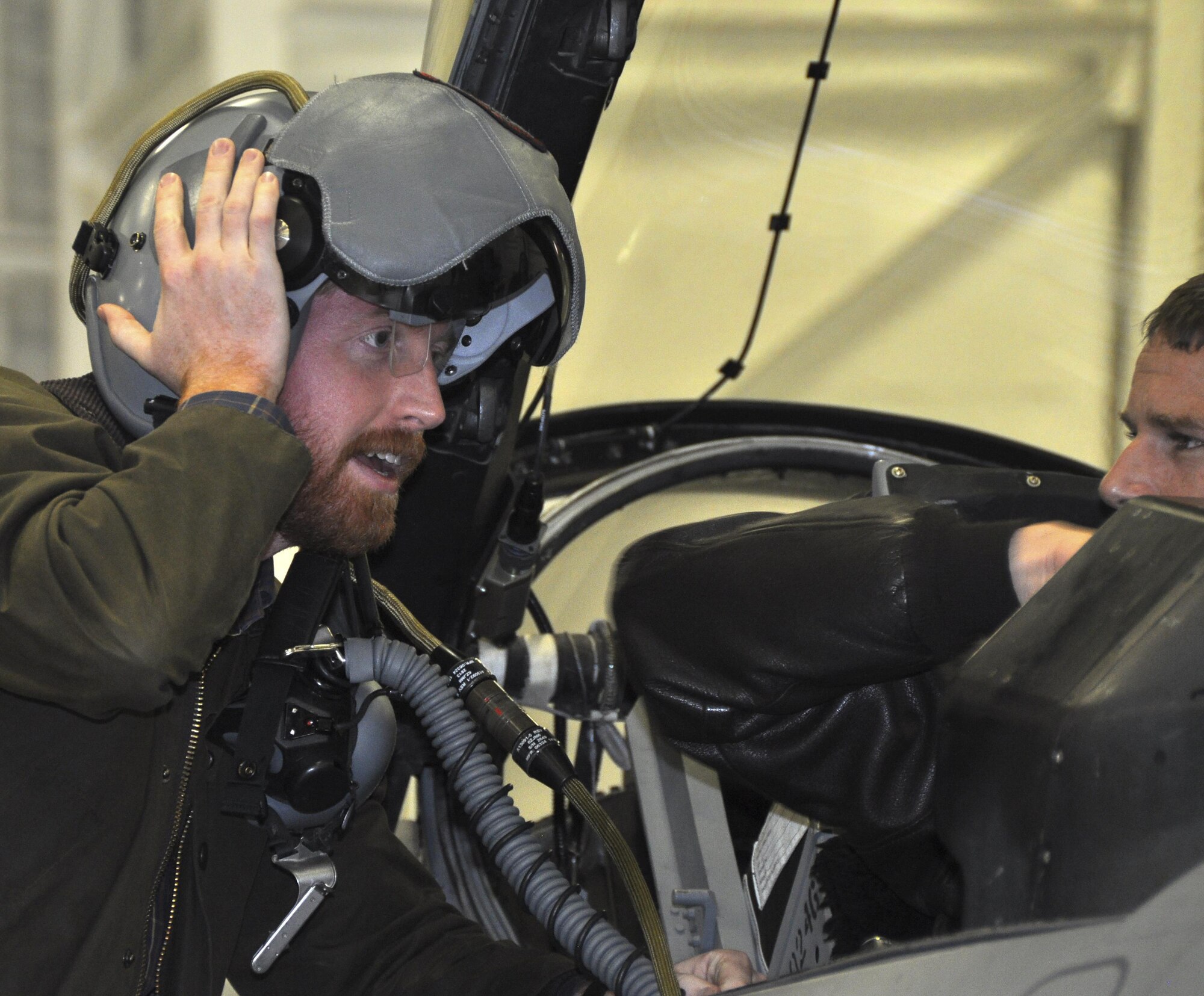 NAVAL AIR STATION FORT WORTH JOINT RESERVE BASE, Texas - Congressional staffer Benjamin Cantrell dons a helmet 457th Fighter Squadron F-16 pilots use as Maj. Brett Comer, 457 FS pilot, explains its features Jan. 21 here. The 11-member Congressional delegation visited the 301st Fighter Wing and toured its Explosive Ordnance Disposal, engine shop and F-16 static display. During the tour, 301st Airmen informed Capitol Hill defense staffers of the Air Force Reserve’s value and contributions to the Air Force and Nation by providing hands-on, unit-level perspective. (U.S. Air Force photo by Ms. Julie Briden-Garcia)