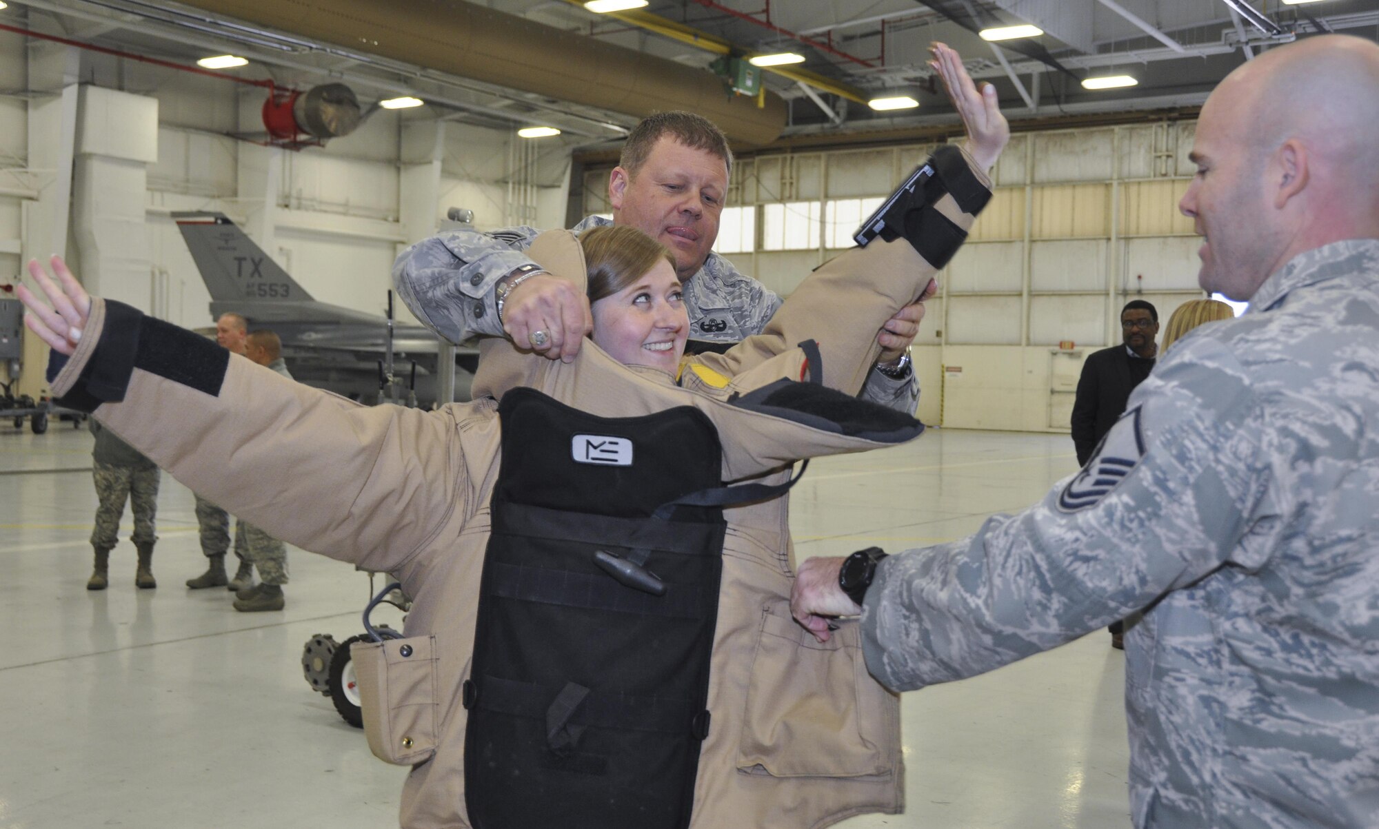 NAVAL AIR STATION FORT WORTH JOINT RESERVE BASE, Texas - Tech Sgt. Guy Smith and Master Sgt. William Warwick, both 301st Mission Support Group Explosive Ordnance Disposal team members, assist Erynn Hook, a Congressional staffer, in donning an EOD suit used to handle explosive devices Jan. 21. Eleven Capitol Hill defense staffers also visited the 301st Fighter Wing’s engine shop and F-16 static display here, as part of the Air Force Reserve-led Congressional Staff delegation four-day winter tour.  (U.S. Air Force photo by Ms. Julie Briden-Garcia)