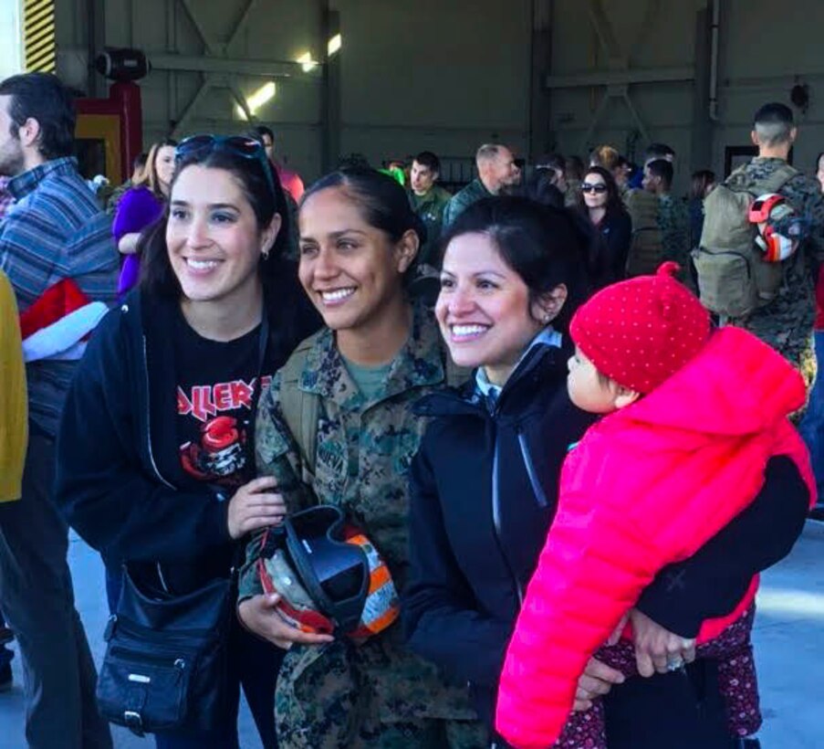 Sgt. Jessica Villanueva, an ordnance Marine with Marine Attack Squadron 311, based out of Marine Corps Air Station Yuma, reunites with her family at the VMA-311 hanger aboard MCAS Yuma, Ariz. Sunday, Dec. 11 2015. VMA-311 was on a six-month deployment in support of the 15th Marine Expeditionary Unit.