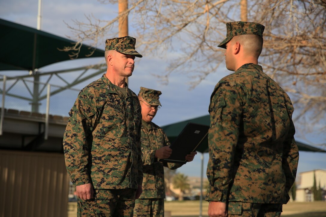 Major Gen. Lewis A. Craparotta, Combat Center Commanding General, and Master Sgt. Todd McKeown, commanding general’s administrative chief, stand at the position of attention as Sgt. Maj. Karl Villalino, Combat Center Sergeant Major, reads McKeown’s promotion warrant at Lance Cpl. Torrey L. Gray Field, Jan. 19, 2016. (Official Marine Corps Photo by Cpl. Julio McGraw/ Released)