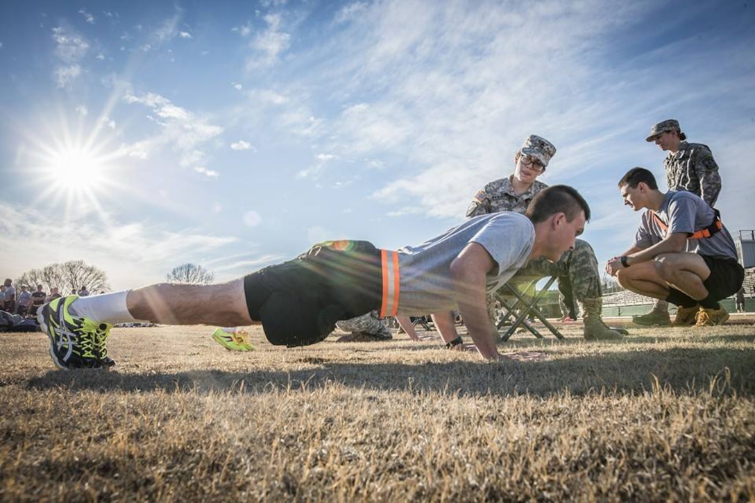 Army ROTC cadet Thomas Mills does pushups while cadet Elizabeth Wilson, seated, grades him during an Army Physical Fitness Test in Clemson, S.C., Jan. 14, 2016. U.S. Army photo by Staff Sgt. Ken Scar