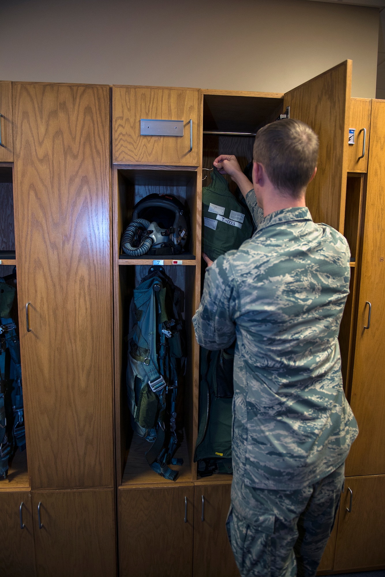U.S. Air Force Airman 1st Class George Schwetz, 23d Operations Support Squadron aircrew flight equipment apprentice, hangs an A-10C Thunderbolt II pilot's G-suit in a locker, Jan. 22, 2016, at Moody Air Force Base, Ga. The AFE life support section is responsible for maintaining and inspecting flight equipment such as harnesses, aircrew helmets, G-suits and flotation devices. (U.S. Air Force photo by Airman 1st Class Greg Nash/Released)