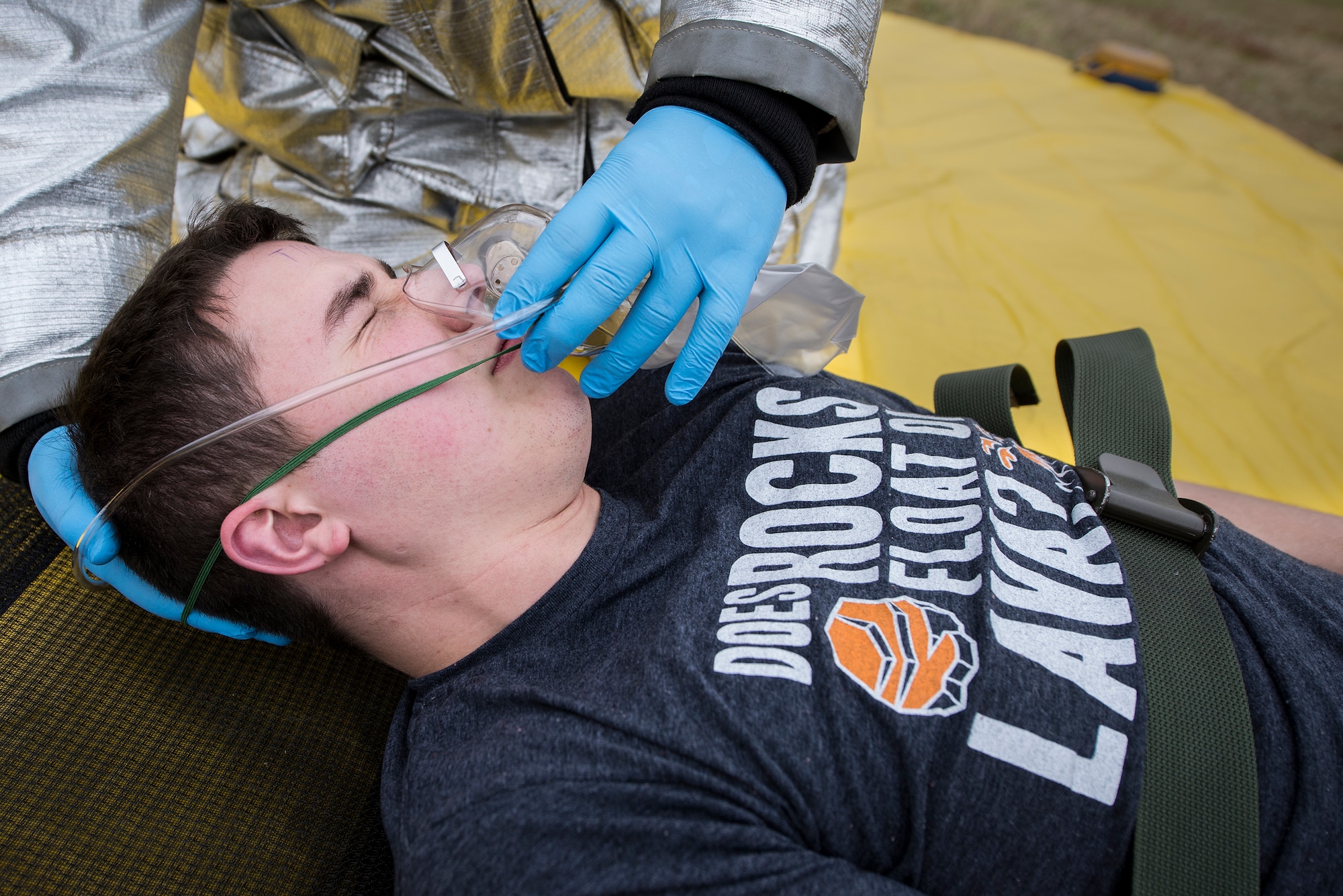An Airman from the 23d Civil Engineer Squadron fire department places an oxygen mask on Airman 1st Class Trevor Stephens, 23d Equipment Maintenance Squadron armament technician, during an active shooter exercise, Jan. 21, 2016, at Moody Air Force Base, Ga. Stephens acted as a simulated injured victim who suffered a gunshot wound to his upper leg. The oxygen mask was applied in order to keep the victim stable during treatment. (U.S. Air Force photo by Airman 1st Class Lauren M. Johnson/Released)