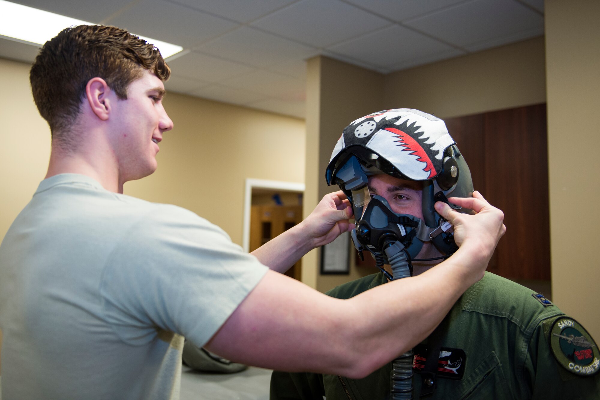 U.S. Air Force Senior Airman Logan Caldwell, 23d Operations Support Squadron aircrew flight equipment journeyman, adjusts Capt. Eric Calvey’s, 75th Fighter Squadron A-10C Thunderbolt II instructor pilot, helmet, Jan. 22, 2016, at Moody Air Force Base, Ga. The AFE life support section provides customer service to the 23d Fighter Group's pilots while ensuring their equipment properly fits and works. (U.S. Air Force photo by Airman 1st Class Greg Nash/Released)  