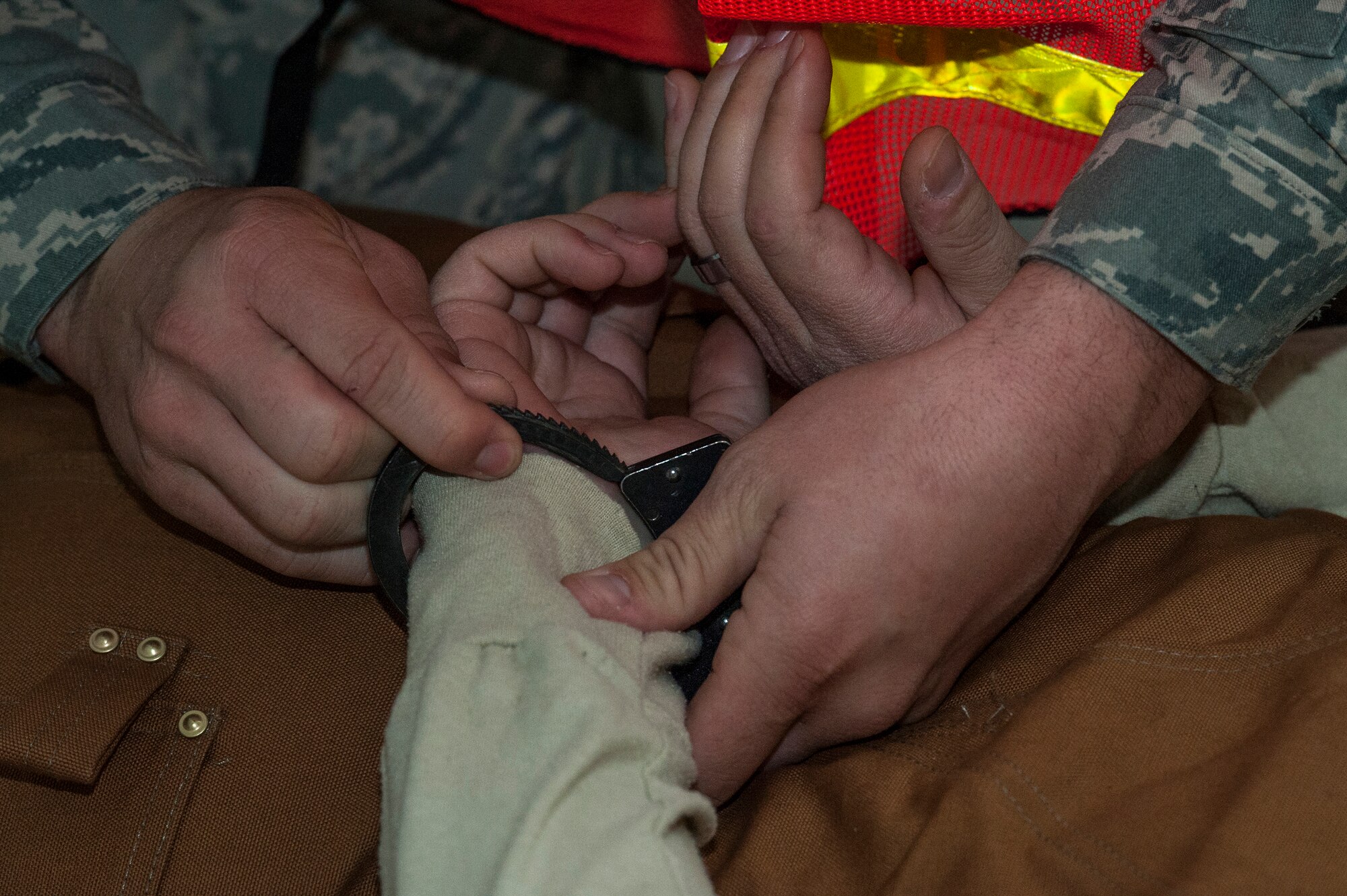 An Airman from the 23d Security Forces Squadron handcuffs the gunman during an active shooter exercise, Jan. 21, 2016, at Moody Air Force Base, Ga. After the gunman was contained and the building was cleared, the medical team moved in to evacuate the simulated dead and injured victims. (U.S. Air Force photo by Airman 1st Class Lauren M. Johnson/Released)