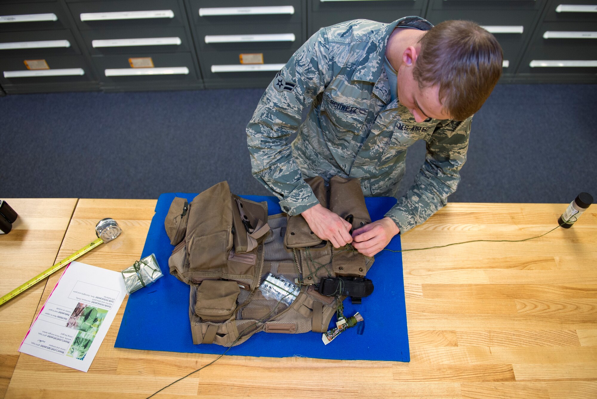 U.S. Air Force Airman 1st Class George Schwetz, 23d Operations Support Squadron aircrew flight equipment apprentice, prepares to standardize components in an Air Ace Survival vest, Jan. 22, 2016, at Moody Air Force Base, Ga. The vest is a life preserver with survival items for pilots in the event of aircraft ejection and contains items such as flares, camouflage paint and chemlights. (U.S. Air Force photo by Airman 1st Class Greg Nash/Released)  