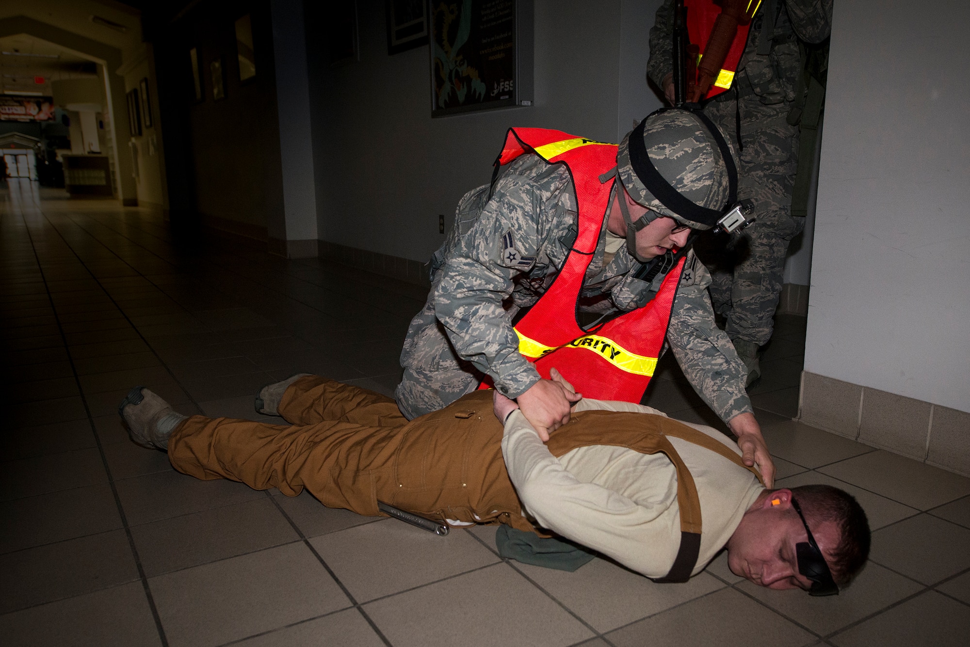 U.S. Air Force Airman 1st Class Matthew McFarlin, 23d Security Forces Squadron patrolman, searches the simulated gunman, Tech. Sgt. Timothy Hartman, 23d SFS kennel master, during an active shooter exercise, Jan. 21, 2016, at Moody Air Force Base, Ga. The 23d SFS Airmen successfully took down the gunman, cleared the building and evacuated the injured victims. (U.S. Air Force photo by Airman 1st Class Lauren M. Johnson/Released)