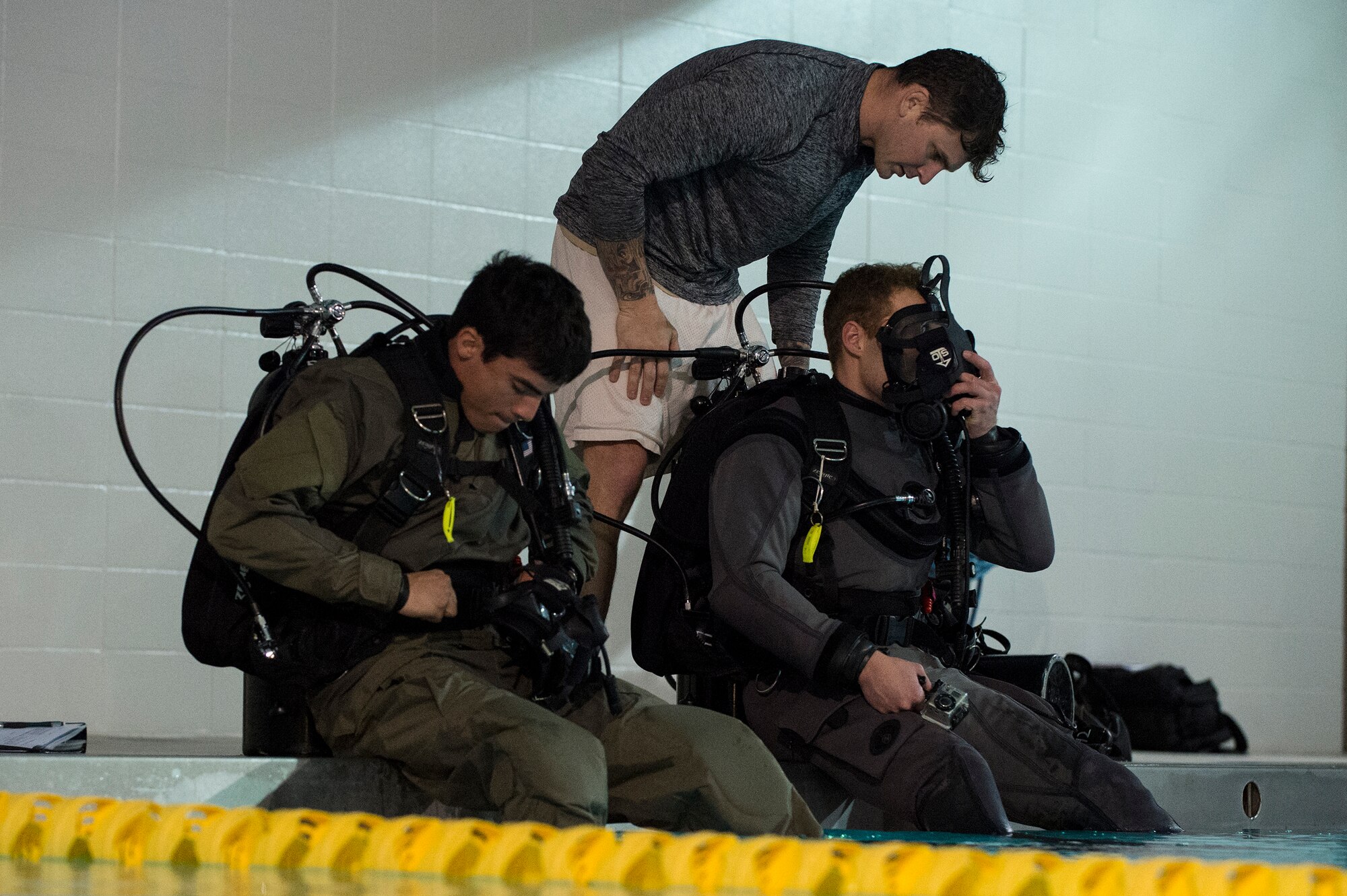 U.S. Air Force Tech. Sgt. Michael Young, 38th Rescue Squadron pararescueman, ensures Senior Airmen Robert Jones, left, and Nate Young, 38th RQS pararescuemen, don their dry suits, Jan. 20, 2016, at Moody Air Force Base, Ga. Dry suits provide pararescuemen with thermal protection during cold water conditions and chemical protection in contaminated water. (U.S. Air Force photo by Senior Airman Ceaira Tinsley/Released)