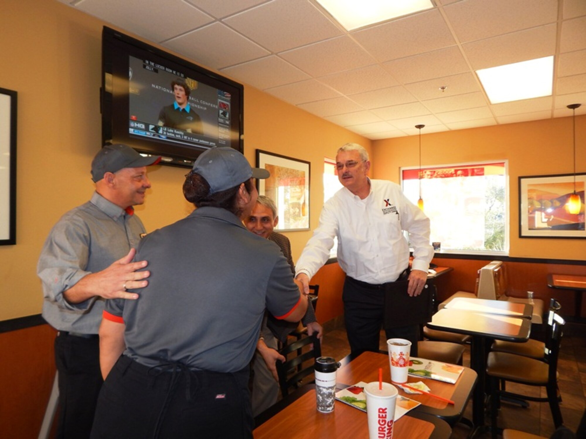 Army & Air Force Exchange Service Deputy Director Mike Immler (right) and Davis-Monthan Exchange General Manager Robin Chetri greet Burger King manager Ron Grandl and food service worker Yolanda Tovar at the Davis-Monthan Exchange food court. Immler toured the food court and other Exchange facilities during his visit to Davis-Monthan AFB, where he also met military leaders to hear about how the Exchange can better serve Airmen at Davis-Monthan. (Courtesy Photo)
