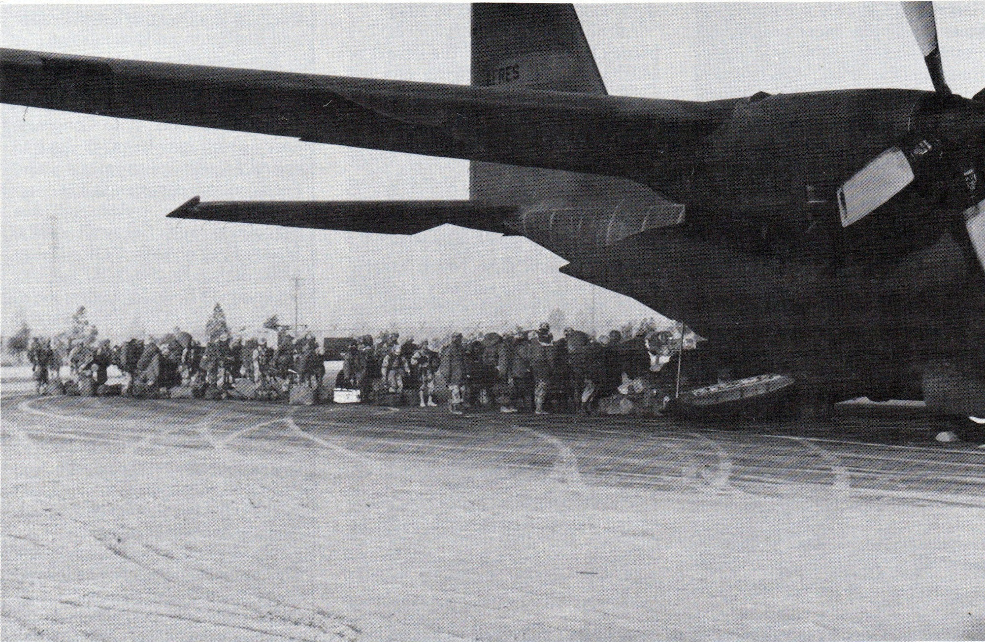 Army troops board a 907th TAG C-130E at desert airstrip. (Courtesy of the 445th Airlift Wing History Office)