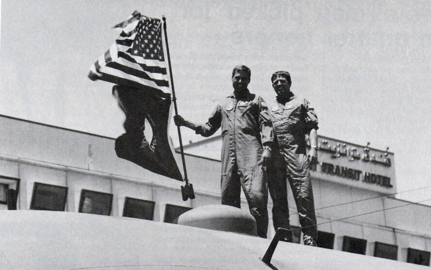 Maj. Robert Shondel and Master Sgt. Charlie Mercer display the U.S. and Kentucky flags while standing atop a C-130E at the Kuwait City Airport. (Courtesy of the 445th Airlift Wing History Office)
