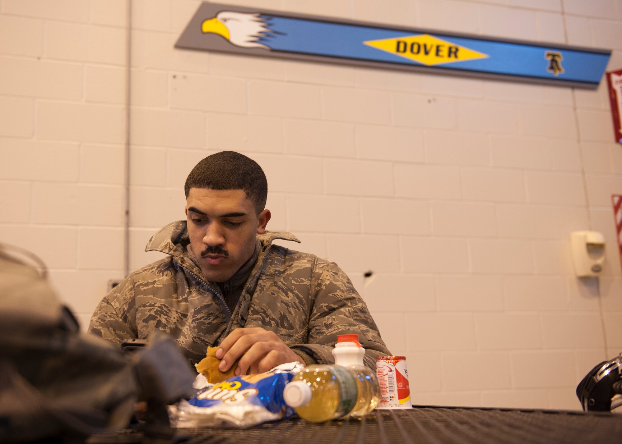 Airman 1st Class Langdon Hammond, 436th Aircraft Maintenance Squadron hydraulics, eats at the newly opened Heavy Lifters flight line food kiosk Jan. 19, 2016, at Dover Air Force Base, Del.
Hammond took advantage of the kiosk’s convenient access and grab-and-go meals. (U.S. Air Force photo/Senior Airman Zachary Cacicia)
