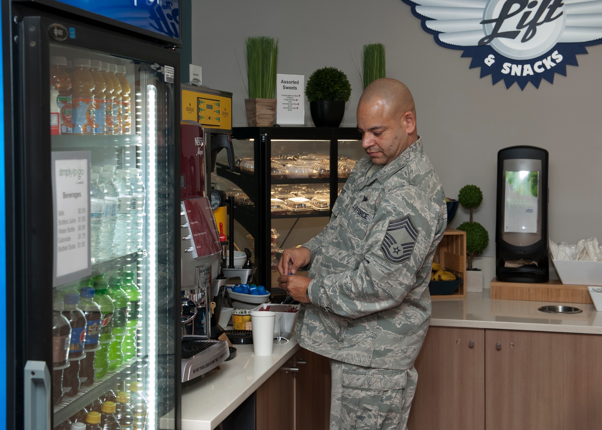 Chief Master Sgt. Geraldo Moore, 436th Operations Group superintendent and 436th Airlift Wing interim-command chief, makes himself a cup of coffee at the newly opened Heavy Lifters flight line food kiosk Jan. 15, 2016, at Dover Air Force Base, Del. This new kiosk provides immediate food access to the north side of the base, an area that had been underserved in the past. (U.S. Air Force photo/Senior Airman Zachary Cacicia)