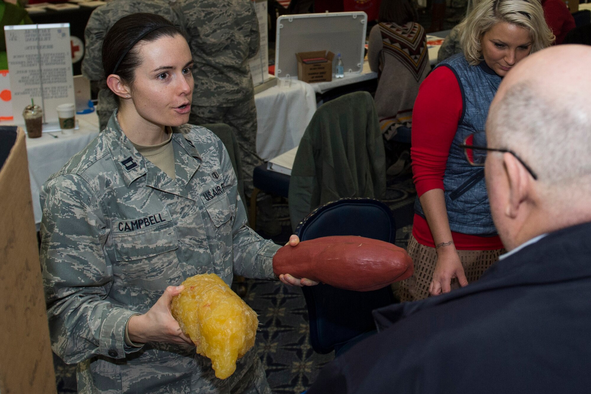 U.S. Air Force Capt. Denise Campbell, 52nd Aerospace Medicine Squadron health promotion dietitian, demonstrates the visual difference between muscle and fat at the Health Celebration in the Club Eifel Ballroom on Spangdahlem Air Base, Germany, Jan. 21, 2016. Campbell had a variety of nutritional displays and information on different food items. (U.S. Air Force photo by Airman 1st Class Luke Kitterman/Released)