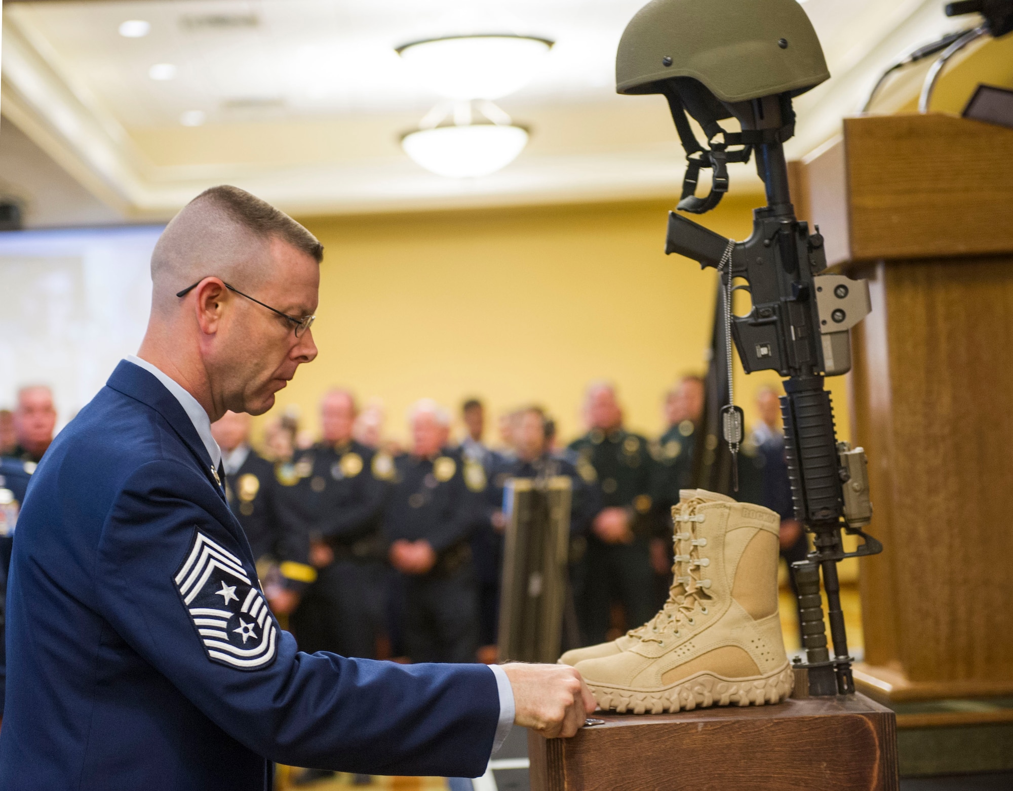 Chief Master Sgt. Bryan Creager, the 96th Test Wing command chief, places his command chief coin on the memorial display during a ceremony for Maj. Adrianna Vorderbruggen at the Soundside on Hurlburt Field, Fla., Jan. 21. Vorderbruggen was a special agent assigned the OSI squadron located on Eglin Air Force Base, Fla.  She was killed in action Dec. 21, 2015 during a deployment to Bagram Airfield, Afghanistan. (U.S. Air Force photo by Senior Airman Krystal M. Garrett)