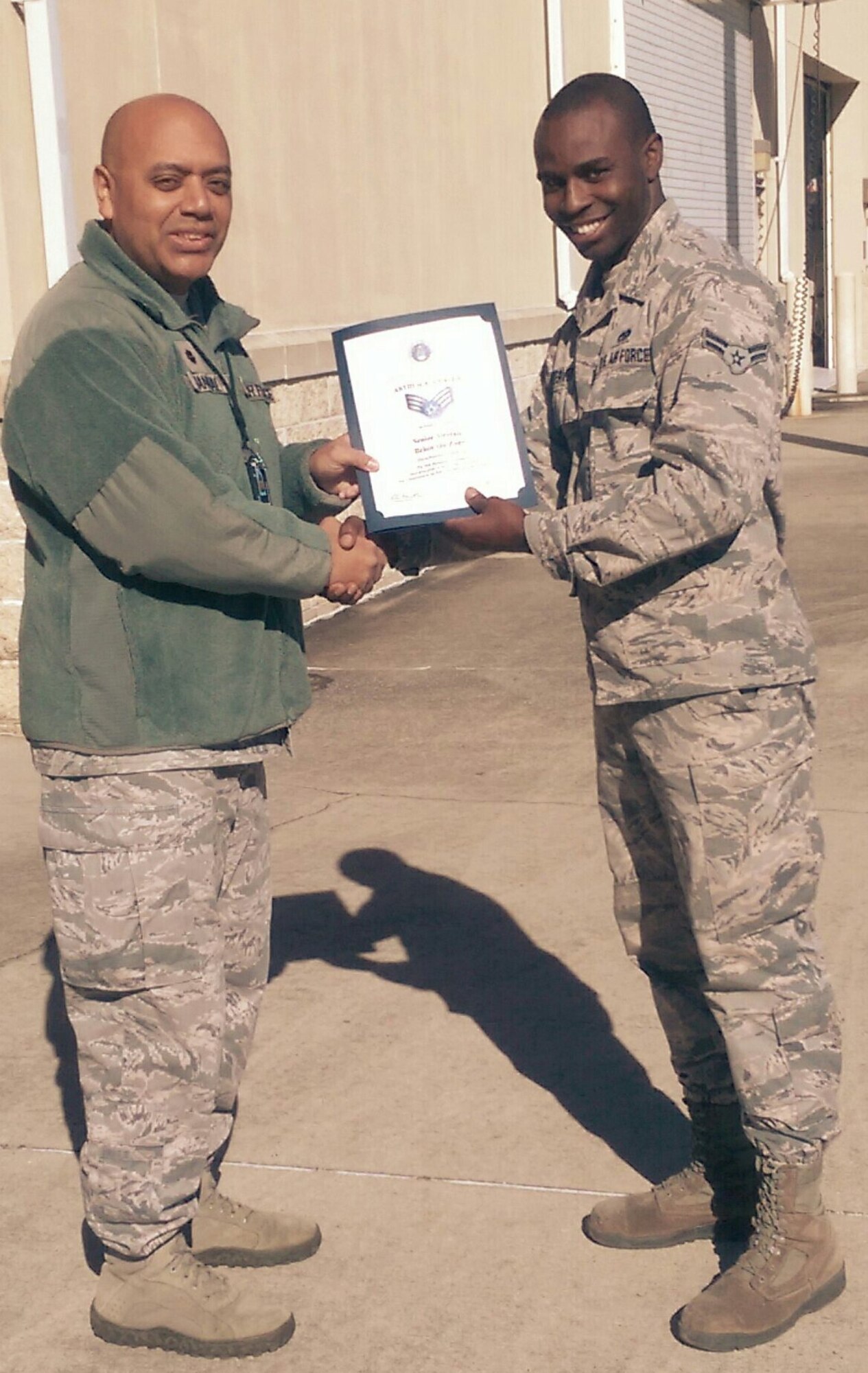 Airman 1st Class Arthur Weaver sent this photo of him with his commander, Maj. Edward Mangual, 96th Maintenance Squadron commander, via text message to his spouse to inform her he had been selected for promotion to senior airman, below the zone Jan. 11 at Eglin Air Force Base, Fla.  The 96th Test Wing selected seven Airmen for the early promotion.  (Courtesy photo)  