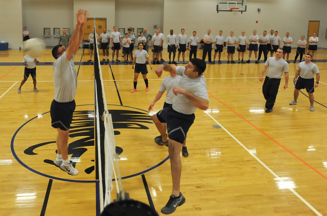 Master Sgt. Ricky Longnecker (left), 22nd Security Forces Squadron first sergeant, attempts a block during a volleyball game, Jan. 19, 2016, at McConnell Air Force Base, Kan. Every Airman Leadership School class competes against the first sergeants in a volleyball game that teaches strategy and teamwork, while players continually rotate in and out of the game. No ALS class has ever beaten the first sergeants since the traditional game was started in 2008. (U.S. Air Force photo/Senior Airman David Bernal Del Agua)