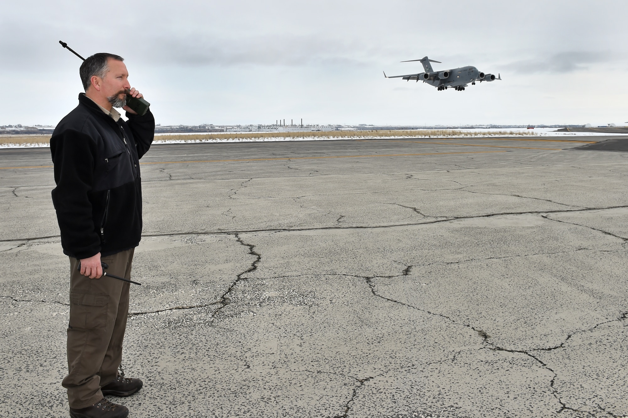 Blaine Barnett, 62nd Operations Support Squadron operations support specialist, talks to a 62nd Airlift Wing C-17 Globemaster III at Grant County International Airport, Wash., assault runway Jan. 15, 2016. Barnett a.k.a. the Iron Cross and his team all of the assault zone operations east of the cascades for the 62 AW. (U.S. Air Force photo/ Senior Airman Naomi Shipley)