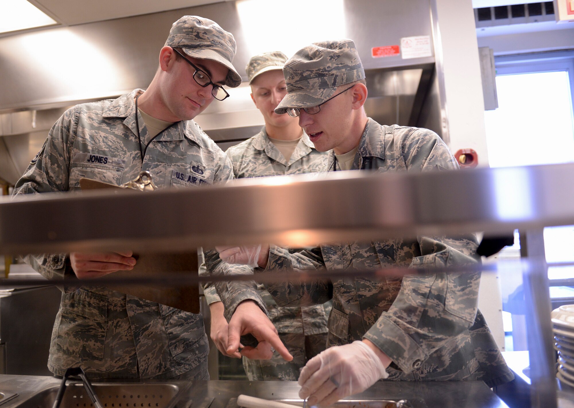 U.S. Air Force Staff Sgt. Daniel Jones, a 509th Force Support Squadron (FSS) in-flight kitchen manager, left, oversees a food temperature-check performed by Senior Airman Justin Stewart, a 509th FSS shift leader at Whiteman Air Force Base, Mo., Jan. 21, 2016. Aside supervising meal-prep, Jones is in charge of the Touch and Go in-flight kitchen’s monthly budget and minor repairs on mission-essential equipment. (U.S. Air Force photo by Senior Airman Sandra Marrero)