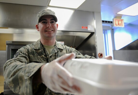 U.S. Air Force Staff Sgt. Daniel Jones, a 509th Force Support Squadron in-flight kitchen manager, hands a meal to a customer at Whiteman Air Force Base, Mo., Jan. 20, 2016. Jones earned the 509th Mission Support Group Supervisor of the Year award through his mentorship and willingness to help his subordinates on and off duty. (U.S. Air Force photo by Senior Airman Sandra Marrero)