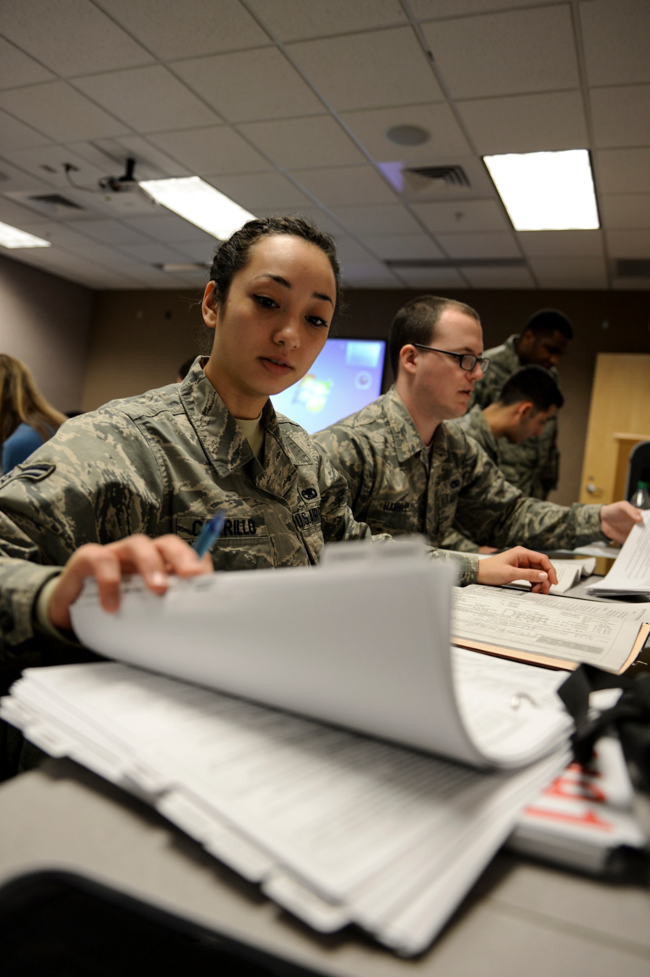 U.S. Air Force Airman 1st Class  Valerie Carrillo, a tax center volunteer, checks tax codes during Volunteer Income Tax Assistance training at Whiteman Air Force Base, Mo., Jan. 19, 2016. Volunteers were taught to handle filing simple, advanced and military tax returns to serve Team Whiteman. (U.S. Air Force photo by Senior Airman Sandra Marrero)