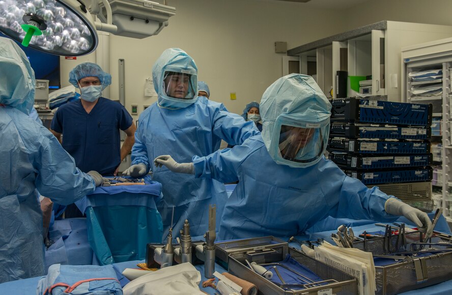 Airman 1st Class Athena Layman, right, 60th Surgical Operations Squadron surgical technician, reaches for a tool Jan. 15, 2016, during a knee replacement surgery at Travis Air Force Base, California, (U.S. Air Force photo by Heide Couch)