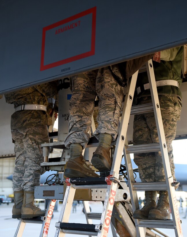 U.S. Air Force Airmen from the 28th Aircraft Maintenance Unit finish locking newly loaded training munitions into place during the Annual Load Crew competition Jan. 15, 2016, at Dyess Air Force Base, Texas. The 28th AMU competed against another load crew from the 9th AMU to see who could transport training munitions off the ground and into the aircraft first. (U.S. Air Force photo by Senior Airman Alexander Guerrero/Released) 