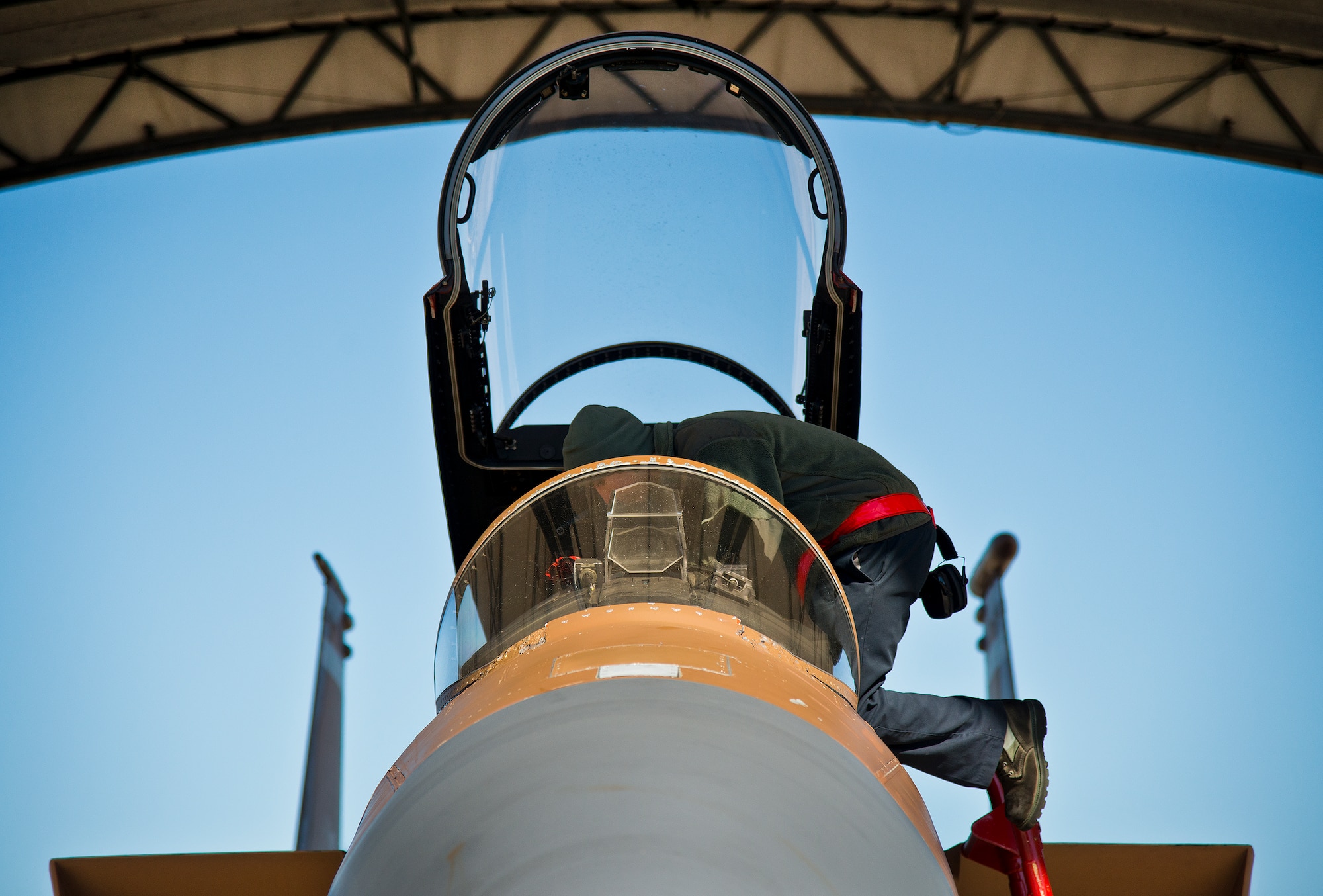 Senior Airman Oscar Mares, 96th Aircraft Maintenance Squadron, prepares an F-15 Eagle’s cockpit for flight prior to a sortie Jan. 20 at Eglin Air Force Base, Fla.  The camouflage aircraft is the only one painted this way on the base. Its Jan. 20 sortie marked the last time it would fly with that paint scheme before being returned to the traditional gray.  The F-15 was painted that way for its role as an aggressor aircraft in combat flight training exercises at Nellis Air Force Base, Nev.  (U.S. Air Force photo/Samuel King Jr.)