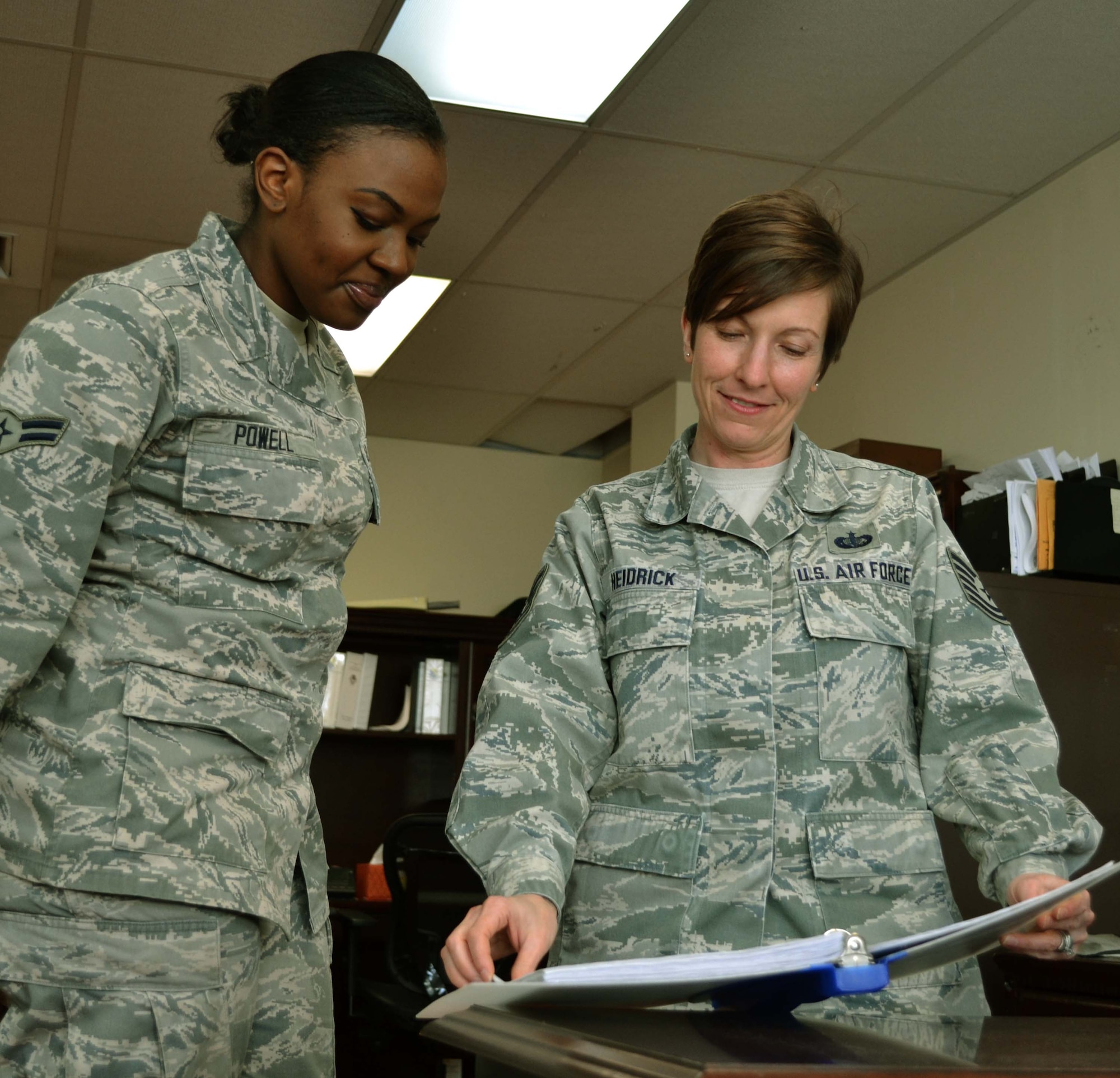 Tech. Sgt. Danielle Heidrick, the 111th Force Support Squadron NCO in charge of the fitness assessment cell and part of the Wing Honor Guard, reviews information about the honor guard to prospective member Airman 1st Class Kamilah Powell, 111th Attack Wing knowledge manager, Jan. 21, 2016, at Horsham Air Guard Station, Pennsylvania. Heidrick worked with the Civil Air Patrol Squadron 801 Honor Guard in Allentown, Pennsylvania, to make it possible for the displaced cadets to practice at Horsham AGS. (U.S. Air National Guard photo by Tech. Sgt. Andria Allmond)
