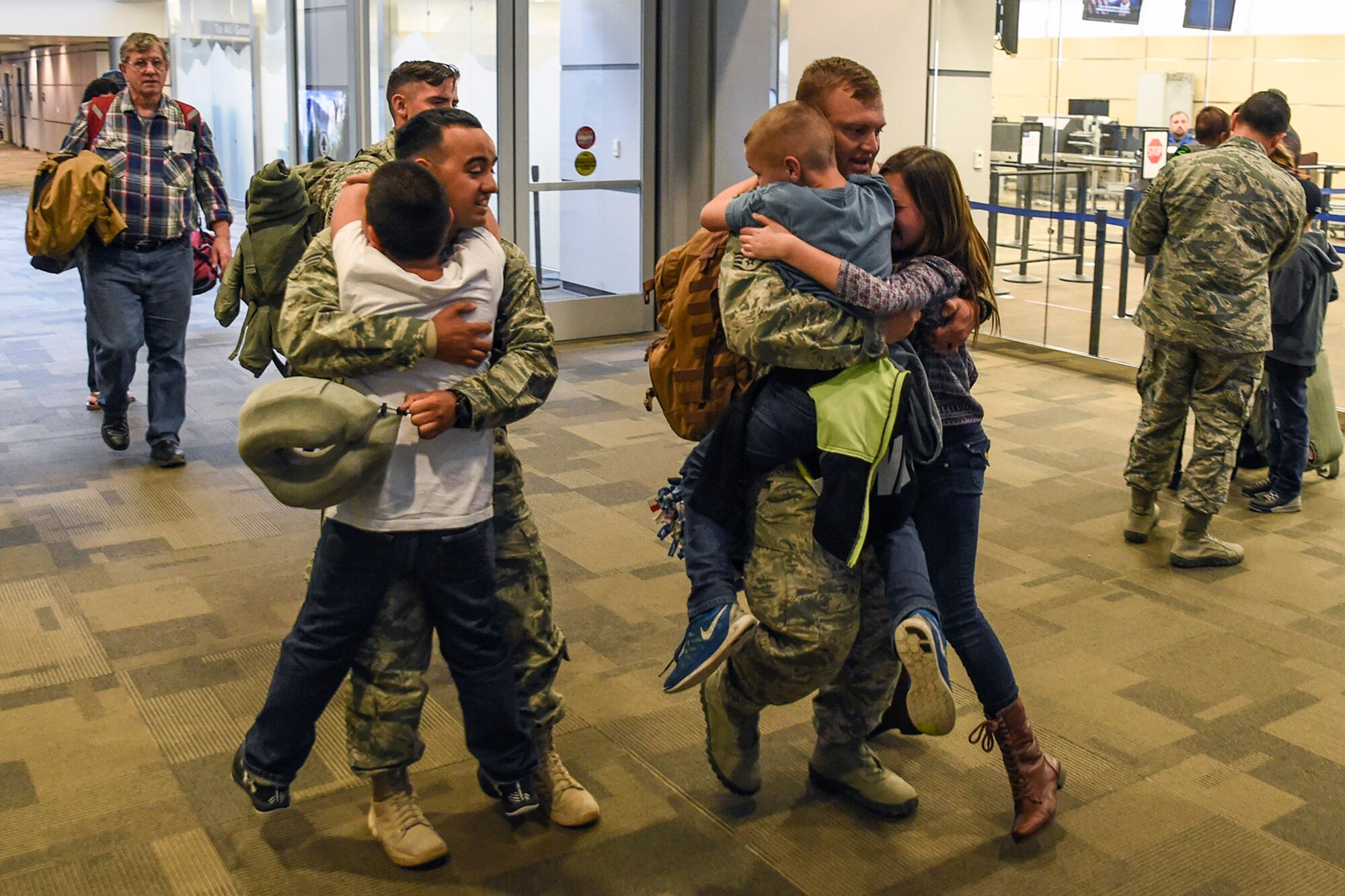 U.S. Air Force Senior Airman Leonardo Perez (left) and Staff Sgt. Kenny Smith (right), both from the 144th Security Forces Squadron, are eagerly greeted by their children at the Fresno Yosemite International Airport Jan. 21, 2015. The 144th Fighter Wing Airmen from Fresno, California were deployed for more than seven months in support of Operation Enduring Freedom. (U.S. Air National Guard photo by Senior Master Sgt. Chris Drudge)