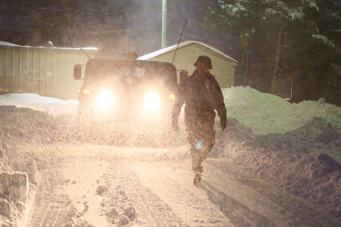 A soldier guides a Humvee preparing to depart from a readiness center to link up with Virginia State Police personnel for possible snow response operations in Staunton, Va., Jan. 23, 2016. U.S. Army photo by 2nd Lt. Jay Haas