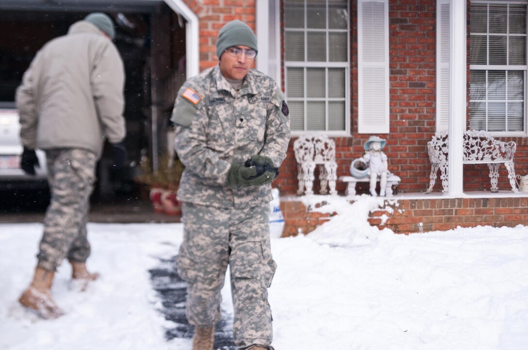 Army Spc. Kevin Thomas salts the walkway for an elderly couple who have been stuck in their homes in the wake of Winter Storm Jonas in Asheville, N.C., Jan. 23, 2016. Thomas is assigned to the North Carolina National Guard’s Headquarters Company, 105th Military Police Battalion. North Carolina National Guard photo Sgt. Brian Godette