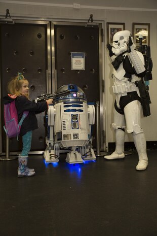 A station resident poses for a photo with R2-D2 and a stormtrooper at the Sakura Theater during a Star Wars: The Force Awakens promotion at Marine Corps Air Station Iwakuni, Japan, Jan. 17, 2016. Richard Inoue, dressed as the stormtrooper spent four years hand building his R2-D2 replica known as R2-J1 and is officially licensed. The promotion provided station residents the opportunity to interact and take group photos with both characters.
