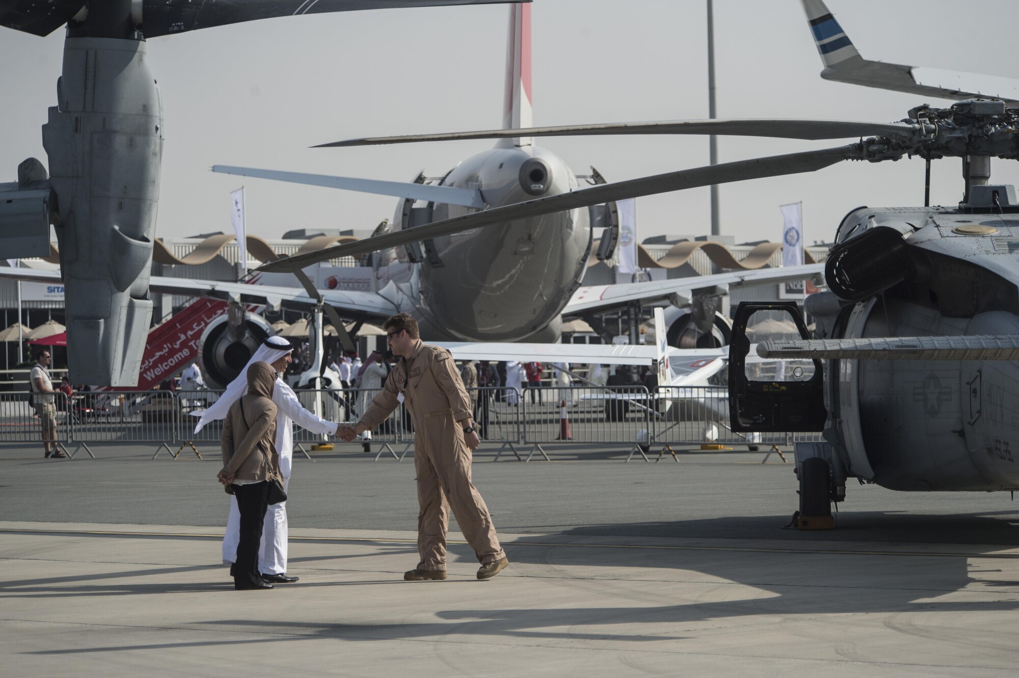 A United States Marine shakes hands with a Bahrain airshow guest at the Bahrain International Airshow at Sakhir Airbase in Manama, Bahrain, Jan. 21, 2016. The Bahrain International Airshow 2016 is a biennial, three-day aviation and aerospace industry event that provides the U.S. military an opportunity to highlight DOD aviation technology. (U.S. Air Force photo by Staff Sgt. Corey Hook/Released)