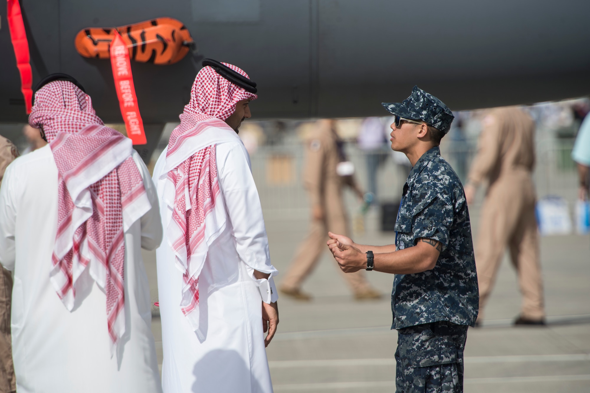 A United States Sailor speaks with Bahrain airshow guests about U.S. military aircraft during the Bahrain International Airshow at Sakhir Airbase in Manama, Bahrain, Jan. 22, 2016. The Bahrain International Airshow 2016 is a biennial, three-day aviation and aerospace industry event that provides the U.S. military an opportunity to highlight DOD aviation technology. (U.S. Air Force photo by Staff Sgt. Corey Hook/Released)