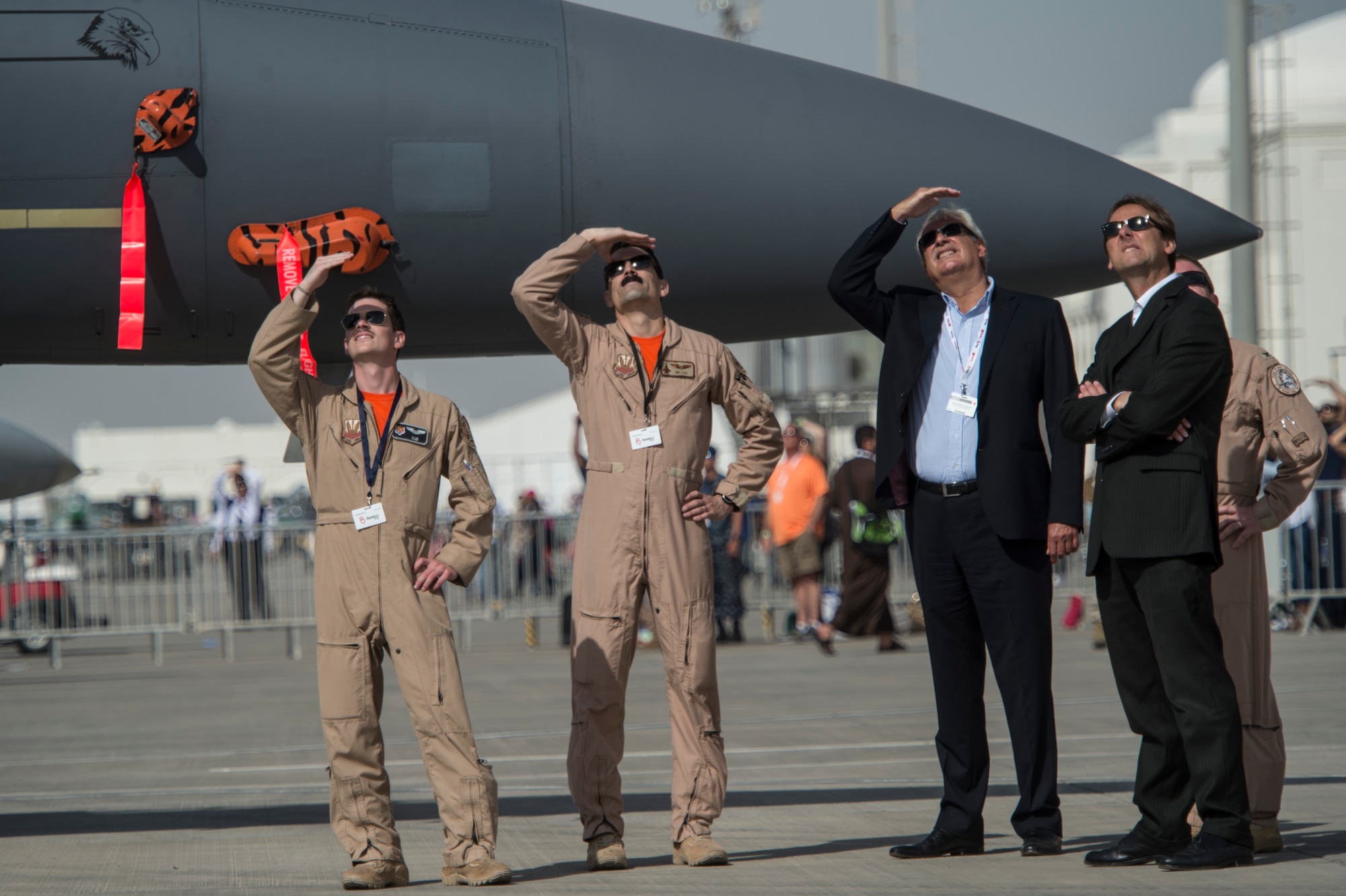 Members from the U.S. military and Bahrain airshow guests watch performing aircraft during the Bahrain International Airshow at Sakhir Airbase in Manama, Bahrain, Jan. 22, 2016. The Bahrain International Airshow 2016 is a biennial, three-day aviation and aerospace industry event that provides the U.S. military an opportunity to highlight DoD aviation technology. (U.S. Air Force photo by Staff Sgt. Corey Hook/Released)
