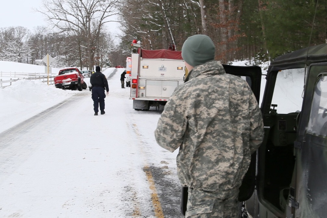 A soldier assists firefighters and Virginia state police as they help a motorist on the side of the road during winter storm response operations in Verona, Va., Jan. 23, 2016. Virginia National Guard photo by 2nd Lt. Jay Haas