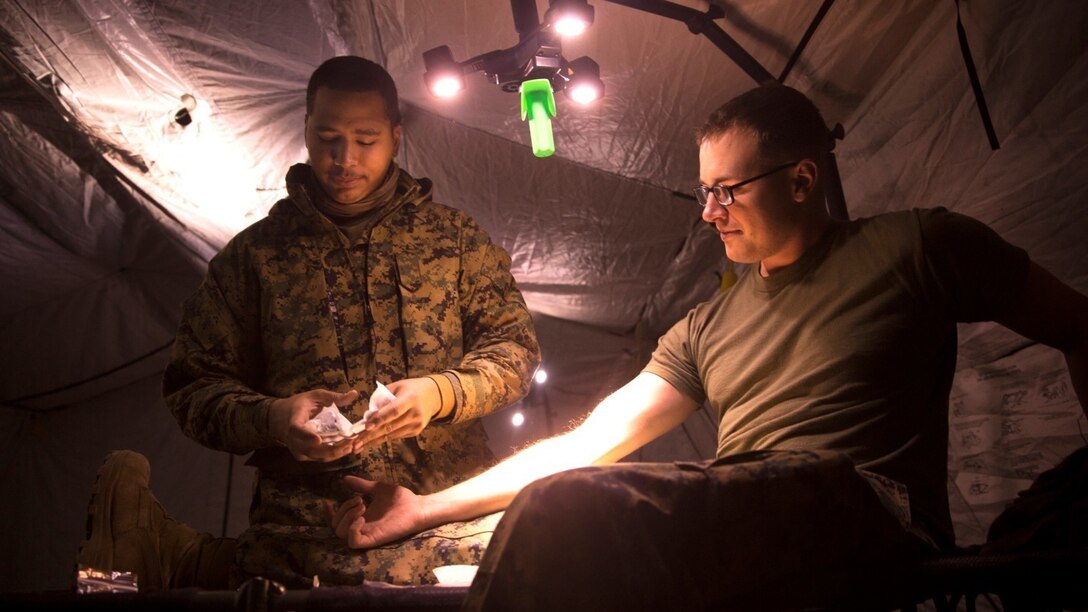 Seaman Damon Oda-Kauhola prepares to place an IV for Petty Officer 3rd Class Cory Richards Jan. 6 in a medical tent at Combined Arms Training Center Camp Fuji, Japan. Corpsman must undergo an additional, more rigorous training program that prepares them to perform their duties under more strenuous conditions to better support the operational forces. Oda-Kauhola and Richards are corpsmen with 3rd Battalion 5th Marine Regiment; currently assigned to 3rd Marine Division, III Marine Expeditionary Force under the unit deployment program. Oda-Kauhola is a Kapolei, Hawaii, native. Richards is an Amsterdam, N.Y., native.