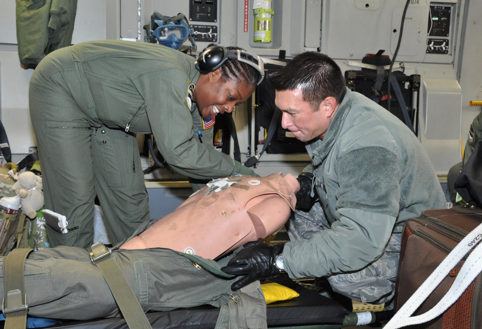 Ministry of presence - Chaplain (Lt Col.) Ronald Apollo (right), 315th Airlift Wing, assists Master Sgt. Latonya Brown, a 315th Aeromedical Evacuation technician, on a recent training mission to Ramstein AB, Germany. (U.S. Air Force Photo by Maj. Wayne Capps)