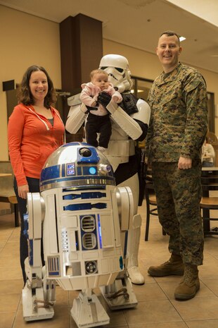 Gunnery Sgt. Clinton Firstbrook, station manager at Armed Forces Network, his wife Kara and daughter Evelyn pose for a photo with R2-D2 and a stormtrooper at the Crossroads Mall during a promotion for Star Wars: The Force Awakens at Marine Corps Air Station Iwakuni, Japan, Jan. 15, 2016. Richard Inoue, dressed as the stormtrooper spent four years hand building his R2-D2 replica known as R2-J1 and is officially licensed. The promotion provided station residents the opportunity to interact and take group photos with both characters.