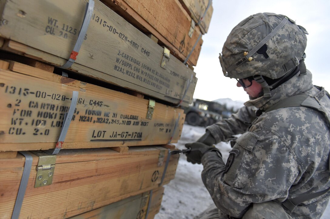 Army Pfc. Luke Dengler unpacks high-explosive rounds while conducting live-fire training utilizing M119A2 105mm howitzers on Joint Base Elmendorf-Richardson, Jan. 11, 2016. Dengler is assigned to the 25th Infantry Division’s 2nd Battalion, 377th Parachute Field Artillery Regiment, 4th Infantry Brigade Combat Team, Airborne, Alaska. U.S. Air Force photo by Alejandro Pena