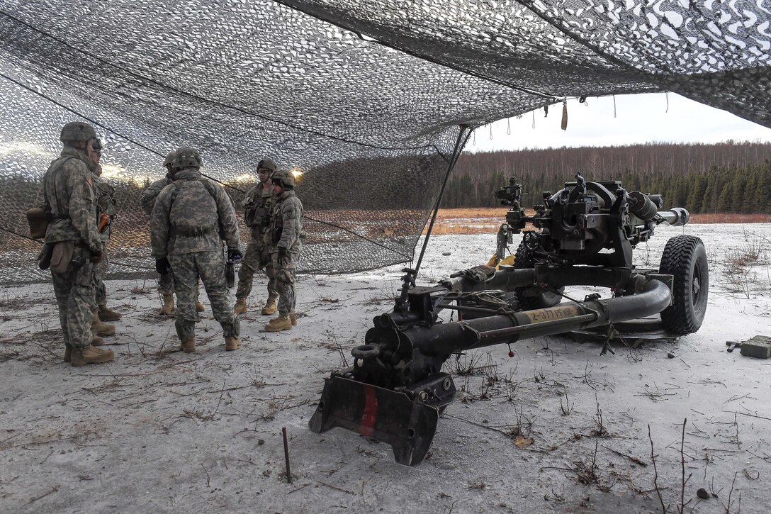 Paratroopers wait by their M119A2 105mm howitzer before conducting live-fire training on Joint Base Elmendorf-Richardson, Jan. 11, 2016. U.S. Air Force photo by Alejandro Pena